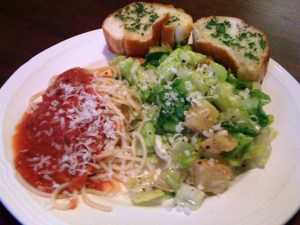 A meatless Italian dinner with bread, salad and pasta.