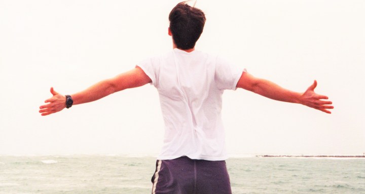Man spreading arms to ocean