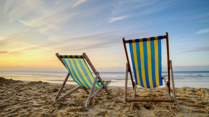 Two empty deck chairs on the beach