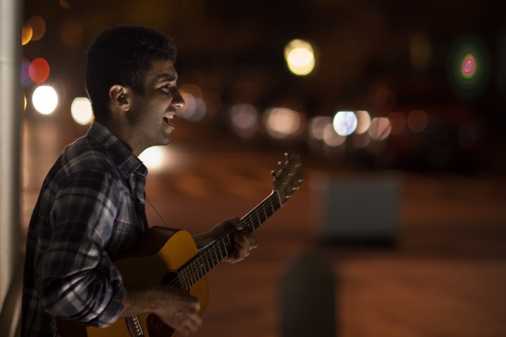 Russell Payan plays guitar under the Washington Square Park arch