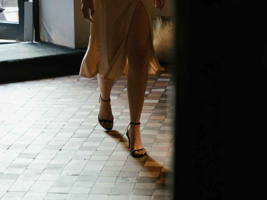 Woman walking across white tiles
