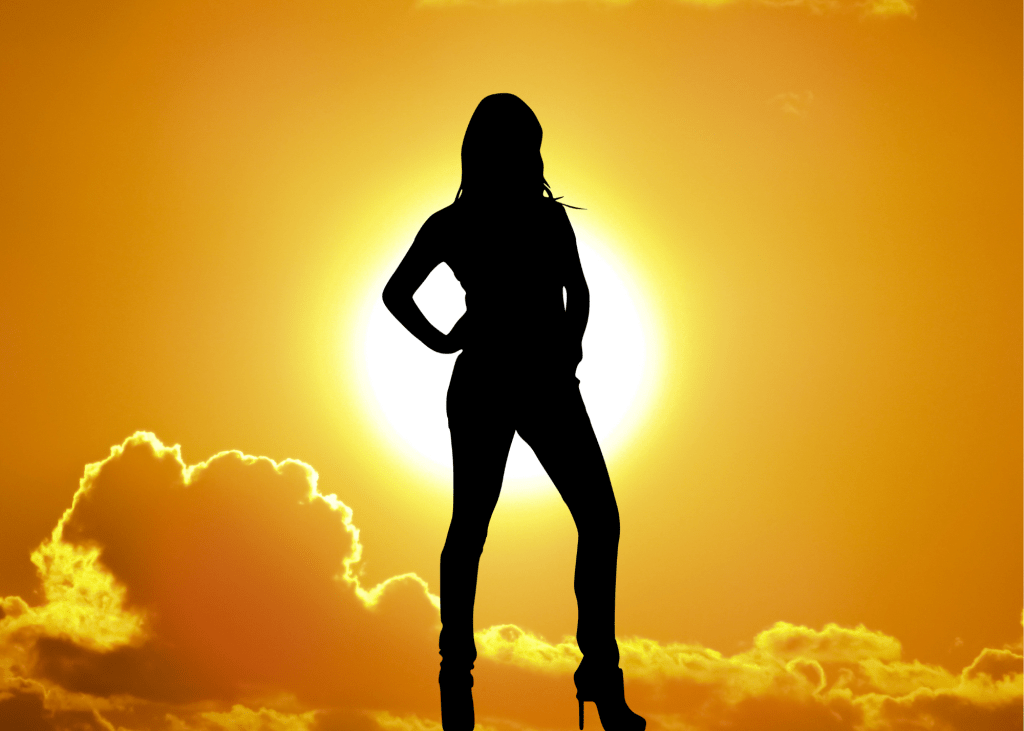 Silhouette of woman standing in daylight.