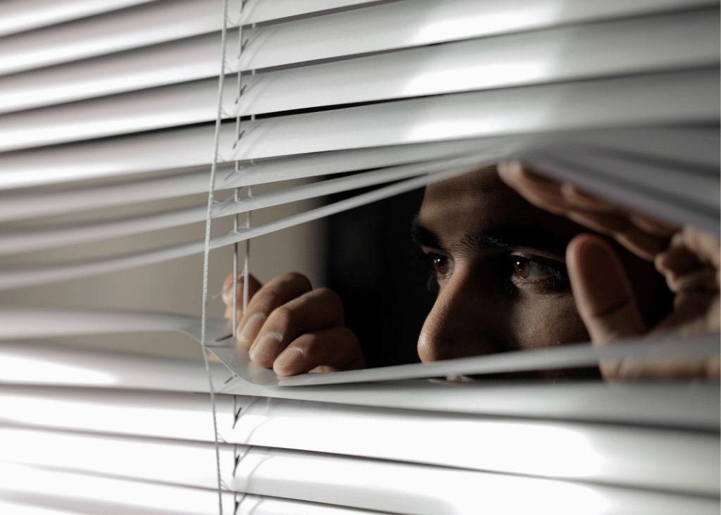 Man peeking through blinds