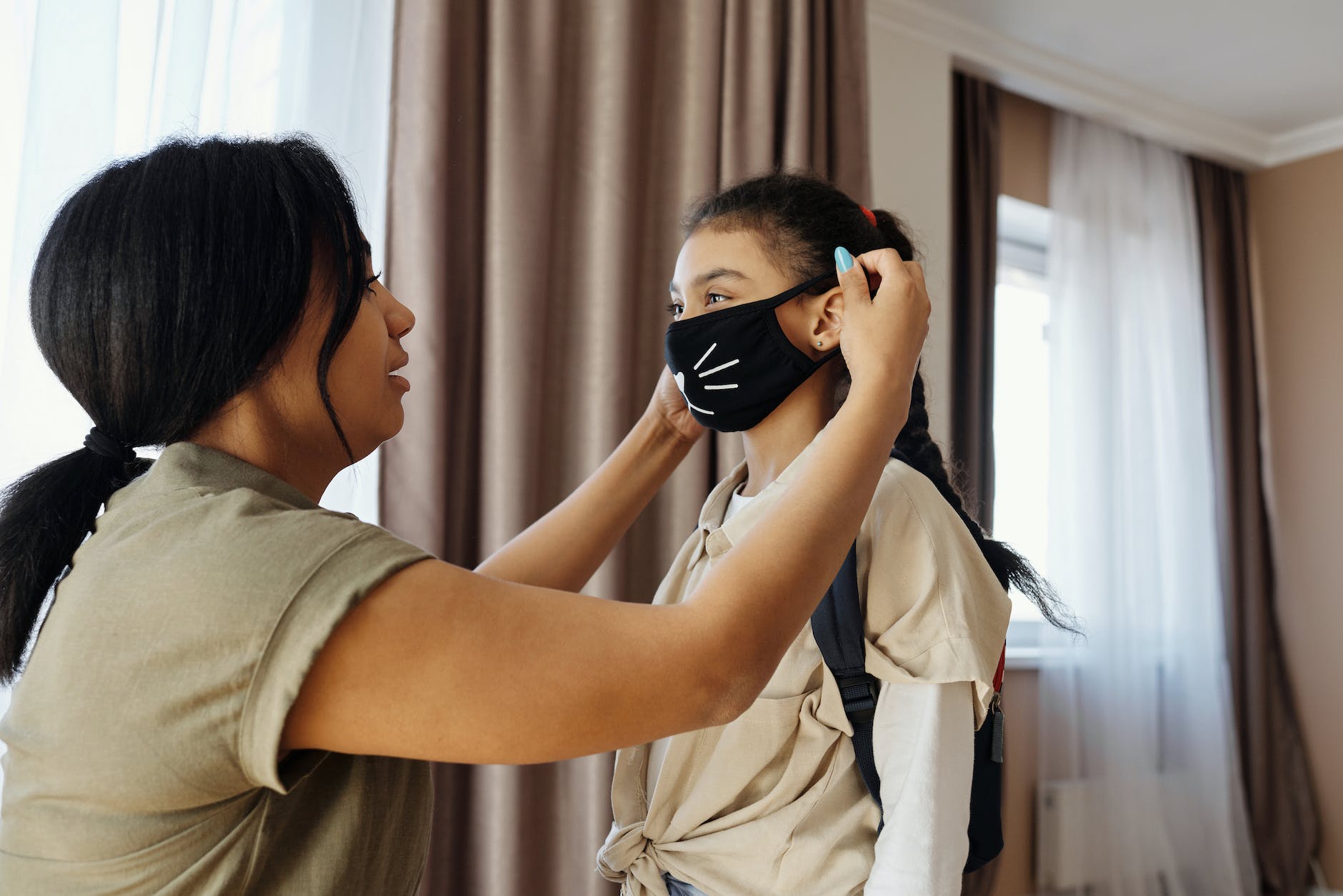 Woman puts a mask on her daughter